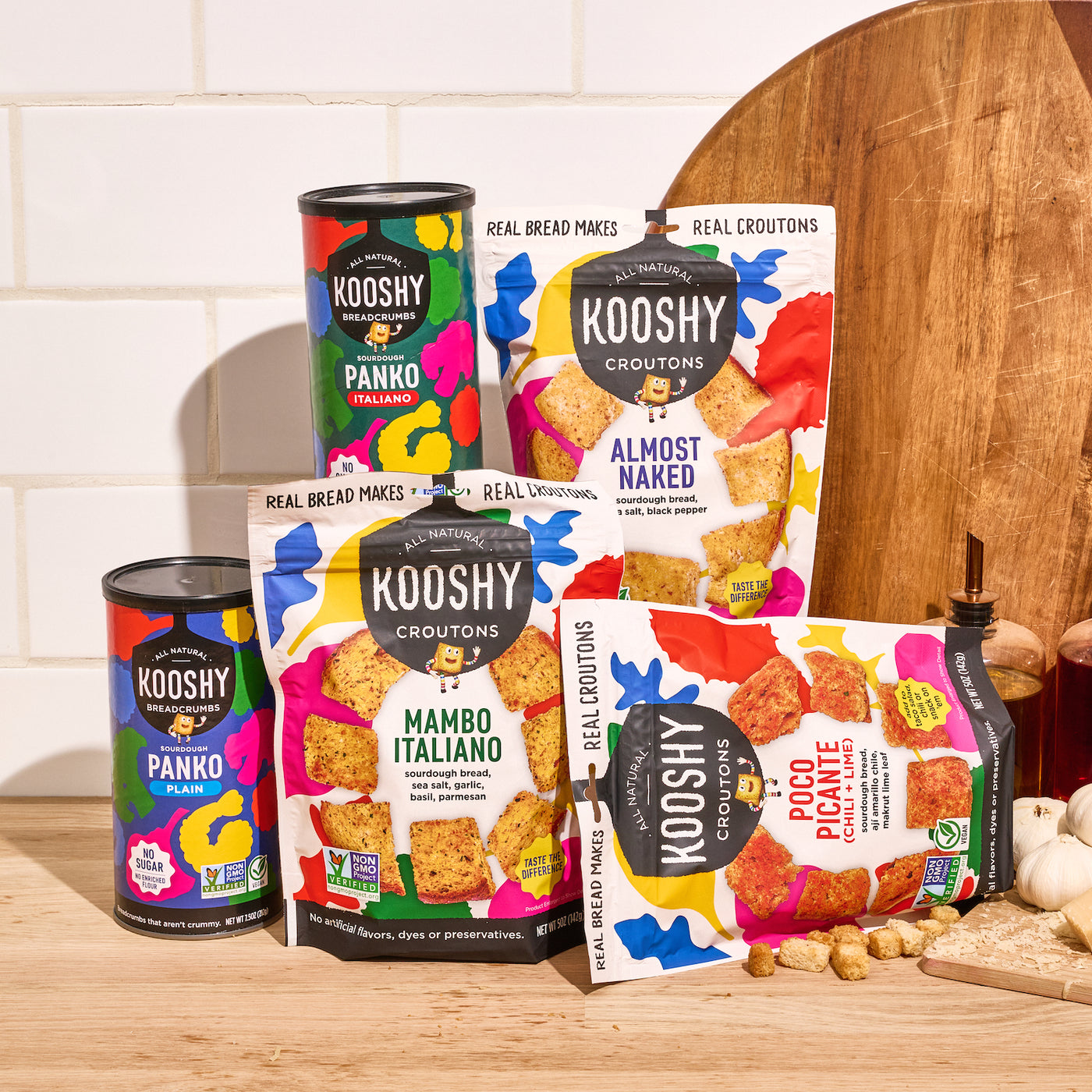 Packaging of kooshy panko breadcrumbs and croutons styled on a wooden kitchen counter.